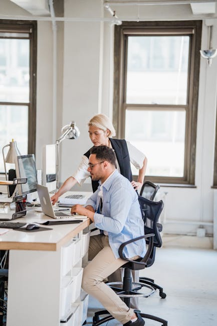 Image shows two professionals working together in a modern office environment, focused on a project. Image shows two professionals working together in a modern office environment, focused on a project.